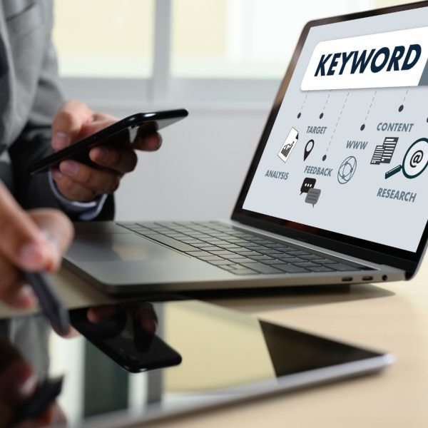 a person in front of the lap top, keyword is written on a screen, concept for PPC and SEO combination