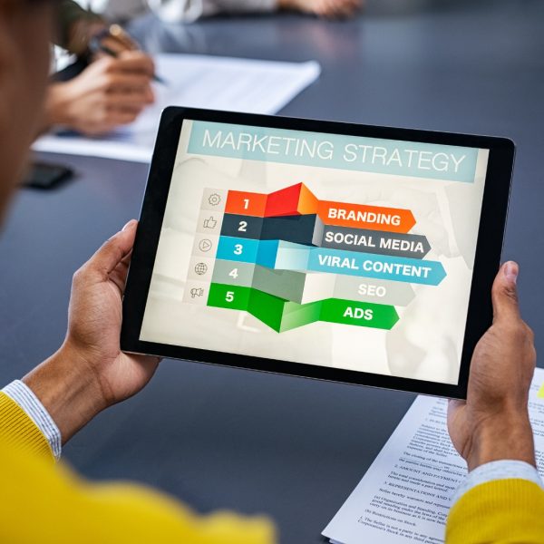 a person is holding a tablet with a marketing strategy graph on the screen